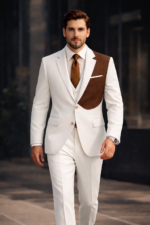 Man wearing a white suit with brown contrast panel walking in a modern urban setting.