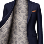 Men's navy blue suit jacket with grey paisley patterned inner lining and pocket square, premium tailored menswear.