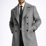 Man wearing a grey double-breasted overcoat over a formal suit and tie, showcasing premium men's tailored outerwear.