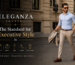 Man wearing a light blue shirt and beige tailored trousers walking confidently on a city street representing Eleganza Traders modern executive style and premium tailoring