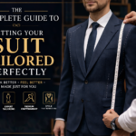 tailor measuring navy suit for perfect fit with tape measure in menswear shop